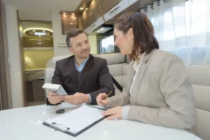 A man wanting to but an RV is discussing his finance options with a broker before making the purchase.