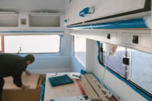 A young man is working on the interior restoration of his used caravan